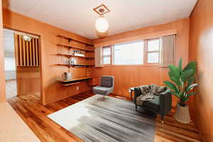 Living area featuring light hardwood / wood-style floors and wood walls