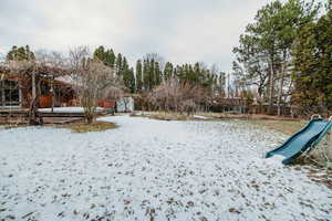 Snowy yard featuring a playground