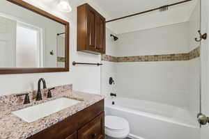 Bathroom with  shower combination, vanity, and toilet