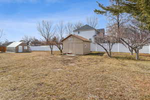 View of yard with an outbuilding, a fenced backyard, and a shed