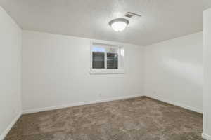 Empty room featuring baseboards, visible vents, and carpet flooring