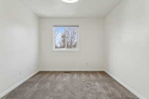 Spare room with carpet flooring, visible vents, and baseboards