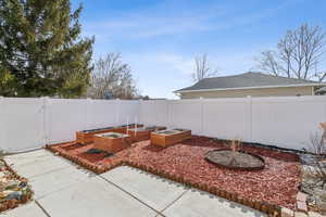 View of yard featuring a garden, a gate, and a fenced backyard