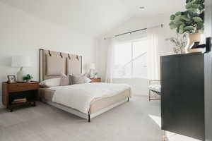 Bedroom featuring light carpet and vaulted ceiling