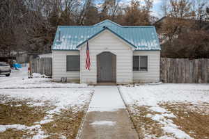 View of front facade featuring metal roof and fence