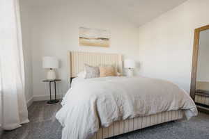 Carpeted bedroom with lofted ceiling and baseboards