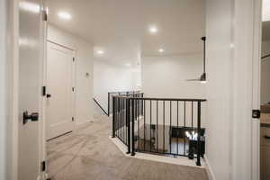 Hall with recessed lighting, carpet, baseboards, and an upstairs landing