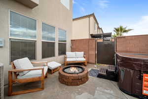 View of patio featuring an outdoor fire pit and fence