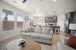 Living area featuring light wood finished floors, visible vents, and recessed lighting