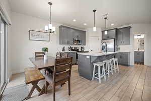 Kitchen with stainless steel appliances, gray cabinets, light countertops, visible vents, and wood tiled floor