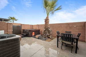 View of patio featuring outdoor dining area, a fenced backyard, and central air condition unit