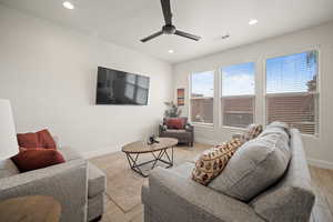 Living room with light wood-style flooring, visible vents, baseboards, and recessed lighting