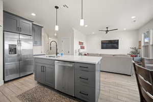 Kitchen featuring gray cabinets, light countertops, visible vents, appliances with stainless steel finishes, and a sink