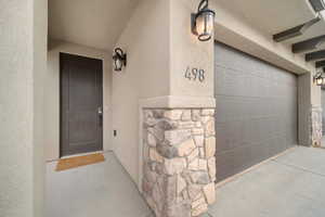 View of exterior entry with stone siding and stucco siding