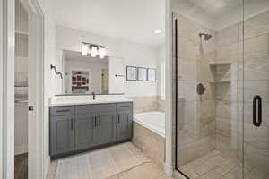 Bathroom featuring a stall shower, vanity, and a bath