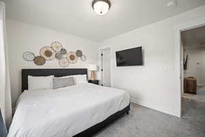 Bedroom featuring a textured ceiling, carpet floors, and baseboards