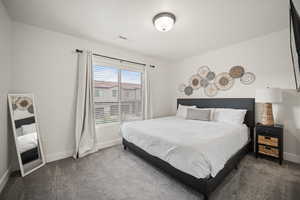 Bedroom featuring carpet floors, baseboards, and visible vents