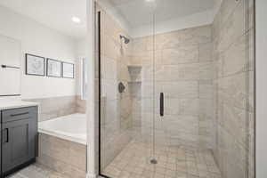 Bathroom featuring a garden tub, vanity, and a stall shower