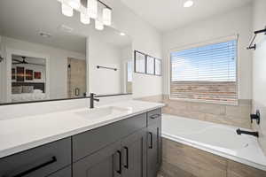 Ensuite bathroom with a garden tub, vanity, visible vents, a shower stall, and ensuite bath