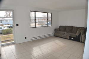 Living area featuring light tile patterned floors and baseboard heating