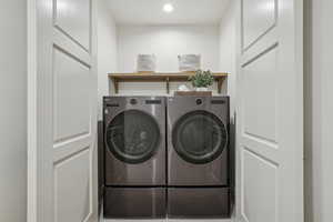 Washroom featuring laundry area, washing machine and clothes dryer, and recessed lighting