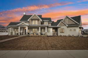 View of front of property with roof with shingles, covered porch, board and batten siding, a standing seam roof, and metal roof