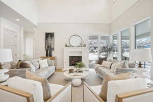 Living room with a fireplace, a high ceiling, and wood finished floors