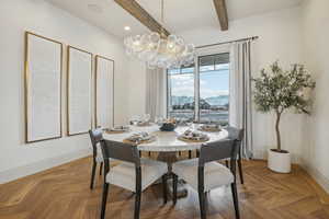 Dining area featuring a notable chandelier, baseboards, a mountain view, and beam ceiling