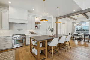 Kitchen with a kitchen island, stainless steel range, and white cabinets