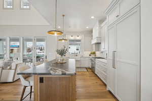 Kitchen featuring high end stove, a kitchen island, white cabinetry, and a kitchen breakfast bar