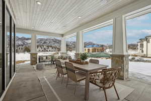 Sunroom / solarium featuring wooden ceiling, a residential view, and a mountain view