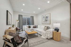 Living room featuring baseboards, carpet flooring, wood ceiling, and recessed lighting