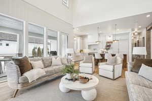 Living room with recessed lighting, a healthy amount of sunlight, and a towering ceiling