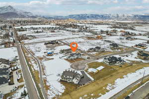 Snowy aerial view featuring a residential view and a mountain view