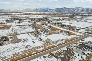 Snowy aerial view featuring a residential view and a mountain view