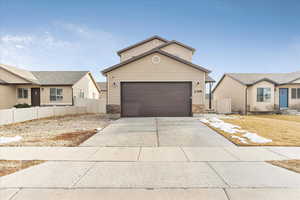 View of front of house with a residential view, fence, and concrete driveway