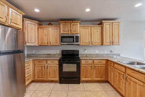 Kitchen with light tile patterned floors, stainless steel appliances, light countertops, and recessed lighting