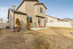 Rear view of house with a patio, fence, a mountain view, and central air condition unit