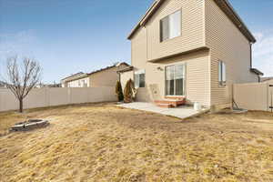 Back of property with an outdoor fire pit, a fenced backyard, and a patio