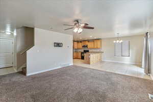 Unfurnished living room featuring light colored carpet, visible vents, and stairway