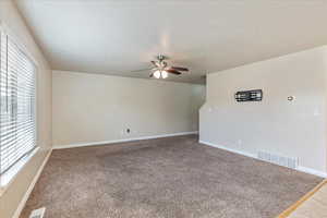 Unfurnished room with a textured ceiling, ceiling fan, visible vents, and baseboards