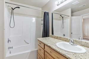 Full bath featuring visible vents, shower / tub combo with curtain, a textured ceiling, and vanity