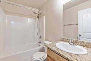 Full bath with visible vents, toilet, a textured ceiling, vanity, and  shower combination