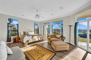 Bedroom with baseboards, visible vents, ornamental molding, wood finished floors, and access to outside