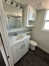 Full bath with visible vents, wood finished floors, a textured ceiling, vanity, and a shower stall