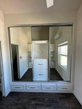 Mudroom featuring dark wood-type flooring, a wall unit AC, and baseboards