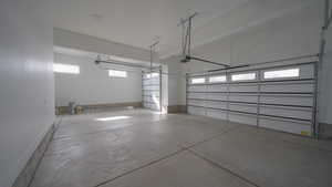 Garage with baseboards and a garage door opener