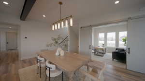 Dining space with a barn door, baseboards, wood finished floors, beam ceiling, and recessed lighting