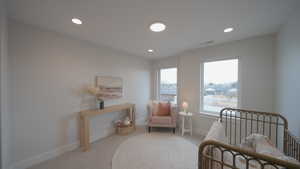 Bedroom with light colored carpet, visible vents, baseboards, and recessed lighting