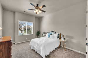 Bedroom with light carpet, ceiling fan, visible vents, and baseboards